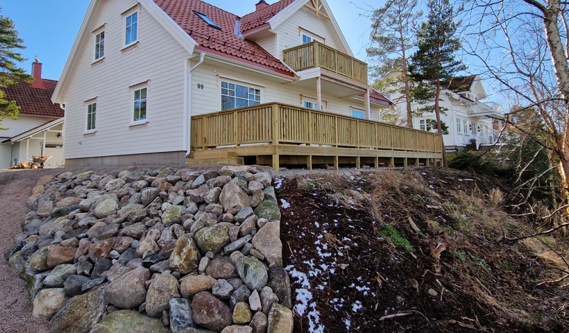 Et stort hvit hus med terrasse nede og oppe bygget av Byggmester Geir Morten Olsen FOTO