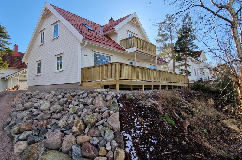 Et stort hvit hus med terrasse nede og oppe bygget av Byggmester Geir Morten Olsen FOTO